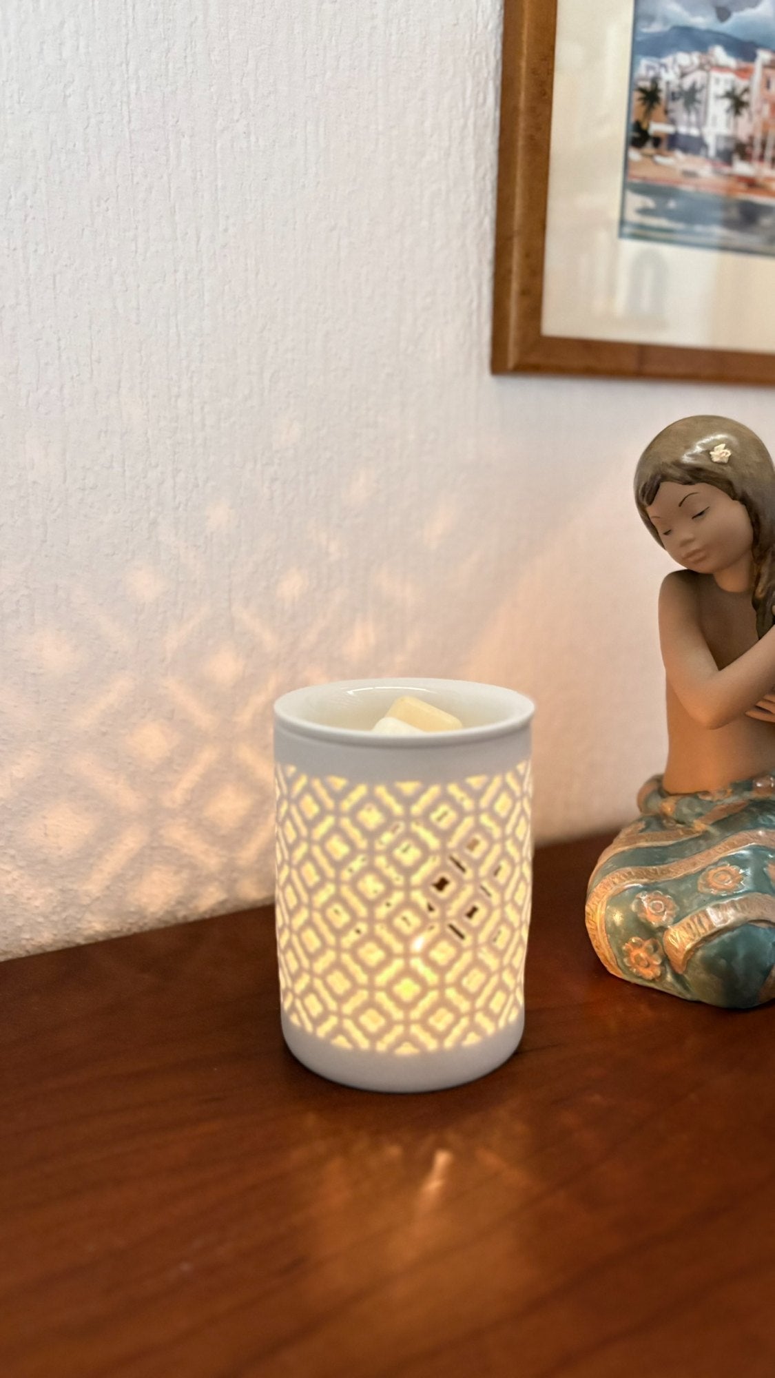 Quemador de cerámica con wax melts sobre una mesita de madera